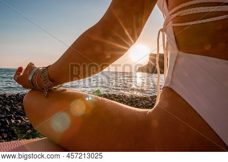 Middle Aged Well Looking Woman In White Swimsuit And Boho Style Braclets Practicing Outdoors On Yoga