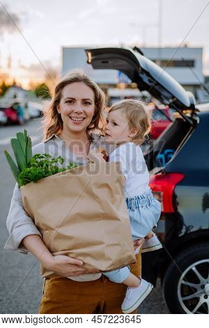 Young Mother With Little Daughter After Shopping Holding Zero Waste Shopping Bags With Grocery Near 