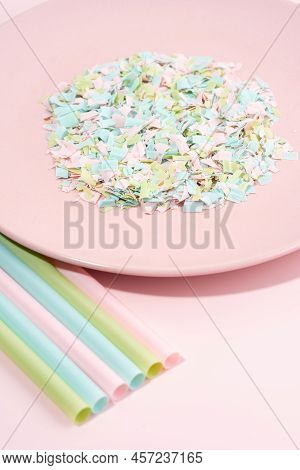 Drinking Straws And Plate Full Of Microplastics On A Pink Background. Impact Of Micro Plastic On The