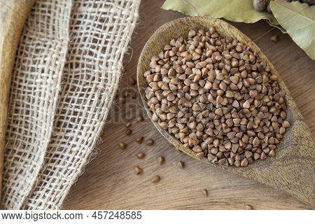 Buckwheat Tea In A Wooden Spoon On A Light Wooden Background. Buckwheat Tea Close-up Macro Photograp