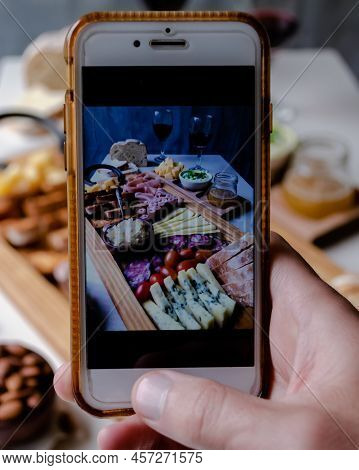 Taking Photograph Of Food Served On The Table With Your Smartphone. Delicious Charcuterie. Picada Ar