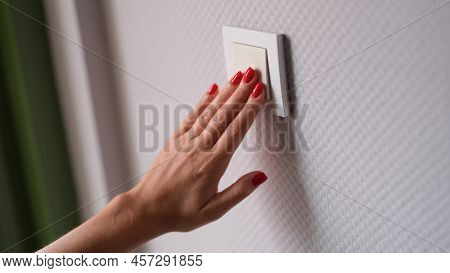 Woman Hand Presses White Light Switch. Stylish Modern Wall Switch Concept