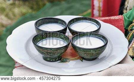 Four Bowls With Traditional Bashkir Pattern, Filled With Mares Milk Or Koumiss, National Drink, On L