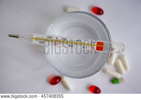 Thermometer, Pills On A Light Background Pharmacy