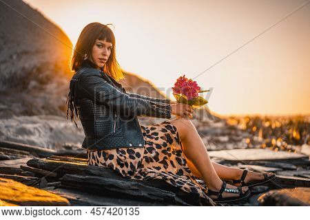 Summer Street Style On A Beach Next To Rocks Of A Young Brunette Caucasian Woman In A Leopard Dress 