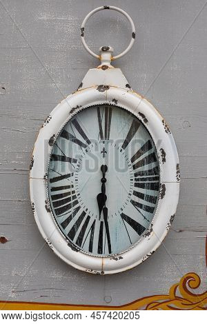 Rusty Vintage Clock Hanging On A Grai Wall