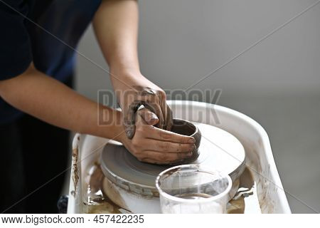 Cropped Shot Ceramicist Creating Handicraft Crockery On The Pottery Wheel In Workshop