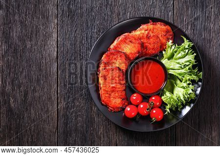 Grilled Slices Of Pork Loin Marinated In Paprika Based Sauce  With Fresh Tomatoes And Lettuce Leaves