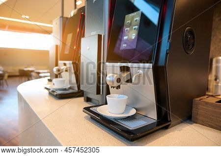 A Beautiful Sun Glare Falls On Self-service Coffee Steam Machines With White Ceramic Coffee Cups In 