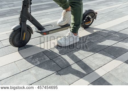 Woman In White Sneakers Standing On Electric Scooter