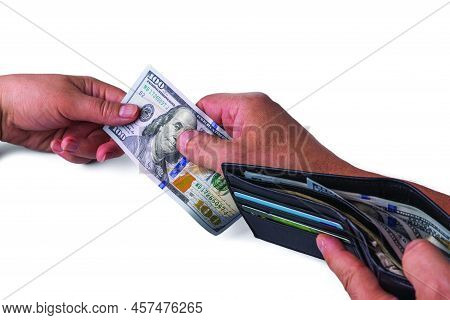 Close Up View Of Female Hand Taking Hundred Dollar Banknote From Man's Hand Holding Wallet With Cash