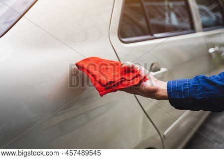 Man's Hand Cleaning Car & Drying Vehicle With Microfiber Cloth. Hand Wipe Down Paint Surface Of Shin