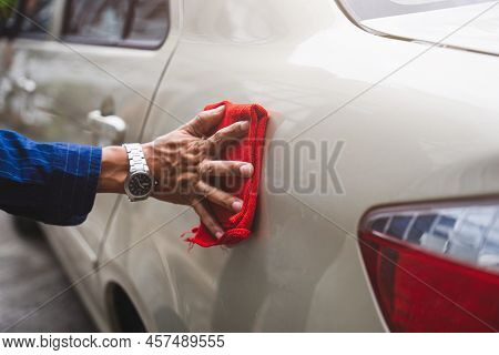 Man's Hand Cleaning Car & Drying Vehicle With Microfiber Cloth. Hand Wipe Down Paint Surface Of Shin