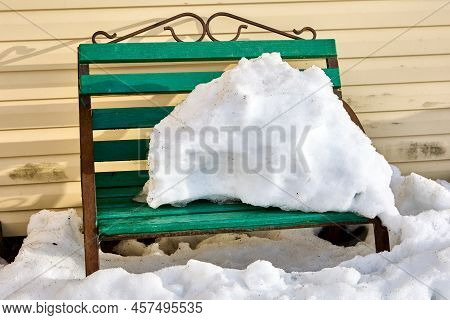 Bank Of Snow On Bench Thaws In Spring In Countryside.