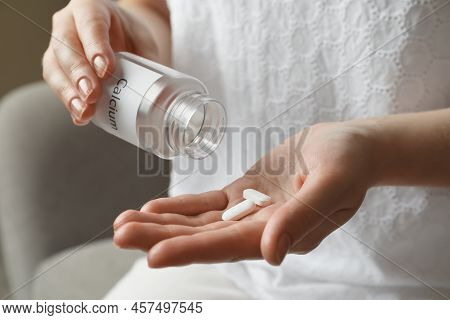 Calcium Supplement. Woman Taking Pills Indoors, Closeup