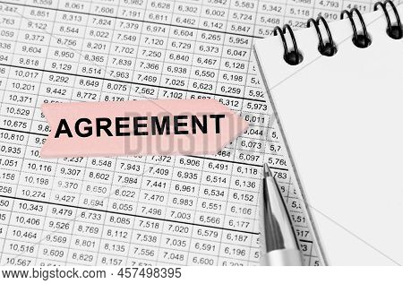 Business Concept. On The Table Among The Reports Is A Notebook, A Pen With An Arrow With The Inscrip