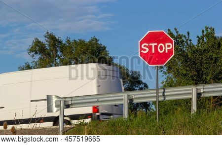 Red Stop Sign With Blue Sky And Clouds Background Of The Road