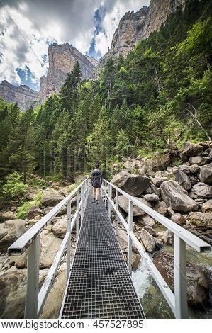 Female Hiker Observing The Cotatuero Waterfall And River In The Ordesa And Monte Perdido National Pa