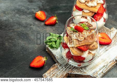 Tiramisu. Homemade Tiramisu With Fresh Strawberry, Mascarpone And Mint In Glass On Dark Background. 