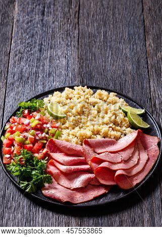 Thinly Sliced Roast Beef Fillet With Quinoa And Tomato Pepper Salsa On Black Plate On Dark Wooden Ta