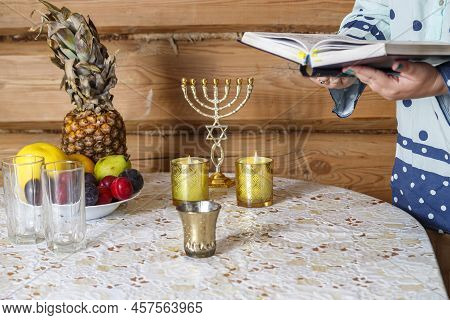 A Jewish Woman, After Lighting Candles, Reads The Evening Prayer Of Maariv According To The Siddur. 