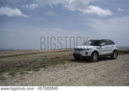 Range Rover Evoque Car On The Background Of The Mountains Of The North Caucasus In Russia. A Clear S