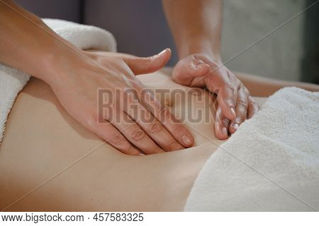Top View Of Hands Massaging Female Abdomen. Therapist Applying Pressure On Belly. Woman Receiving Ma
