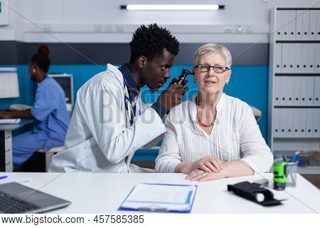 Polyclinic Otologist Consulting Senior Patient Using Otoscope To Check Ear Illness. Clinic Otology S