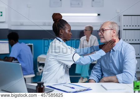 Clinic Specialised Otologist Examining Senior Man While Touching His Neck. Clinic Worker Consulting 