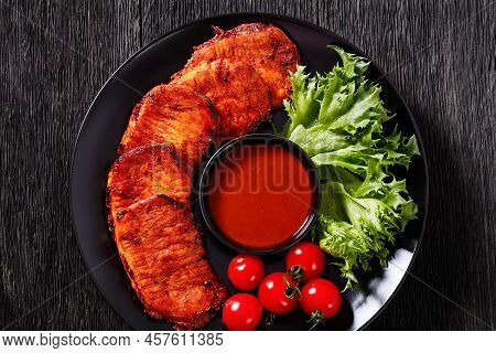 Grilled Slices Of Pork Loin Marinated In Paprika Based Sauce With Fresh Tomatoes And Lettuce Leaves 