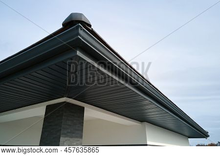 House Corner With Brown Metal Planks Siding And Roof With Steel Gutter Rain System. Roofing, Constru