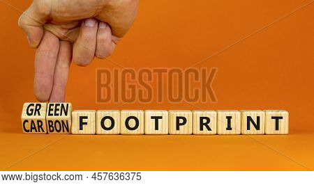Green Or Carbon Footprint Symbol. Businessman Turns Cubes And Changes Words Carbon Footprint To Gree