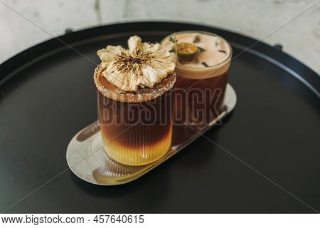 Two Iced Yusu Orange Coffee Special Drinks Served On Black Table In The Cafe.