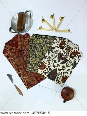 Flat Lay Batik Clotes With Canting, Small Pan And Wax Earthenware Glass Isolated On White Background