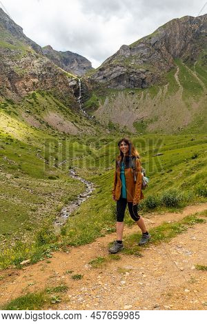 A Young Woman Next To The Salto De Tendenera Waterfall In The Ripera Valley, Panticosa, Pyrenees