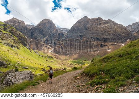 A Young Woman Next To The Salto De Tendenera Waterfall In The Ripera Valley, Panticosa, Pyrenees