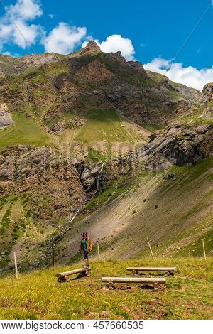 A Young Woman Next To The Salto De Tendenera Waterfall In The Ripera Valley, Panticosa, Pyrenees