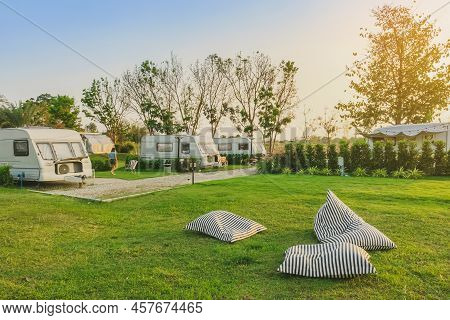 Pillow Or Mattress For Relax On Green Grass With Cozy Retro Travel Trailer Caravan Near Riverside In