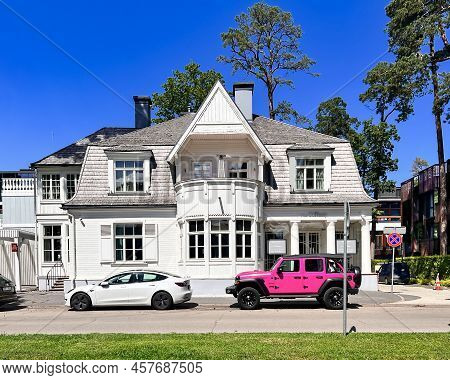 Latvia, Jurmala, July, 2022:  Exterior View Renovation Wooden Home Among Tall Pine Trees On The Quie