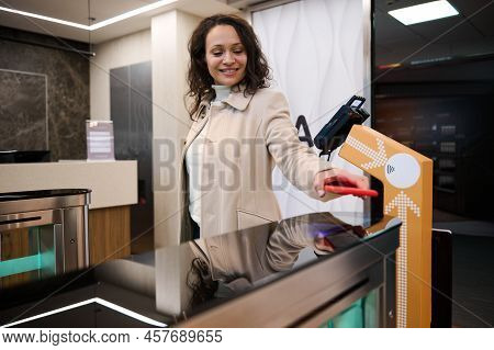 Charming Successful Hispanic Young Woman Placing Her Smartphone Over Qr Code Reader At Check-in Coun