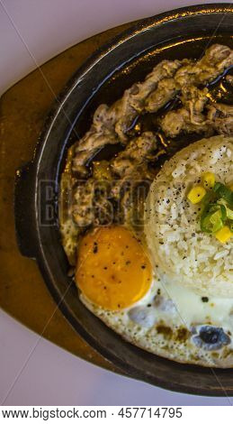 Breakfast With Rice, Fried Egg And Meat Or Beef With Garnish Corn And Leek Close Up Hot Plate Isolat