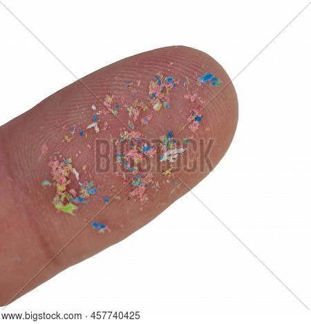 Macro Close-up Of A Microplastic On The Finger Of The Hand. Isolated On White Background