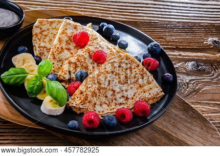 A Plate Of Pancakes With Cheese And Fruits