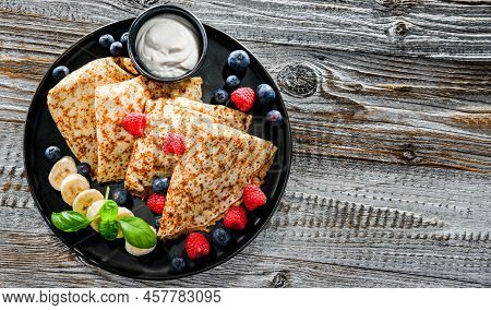 A Plate Of Pancakes With Cheese And Fruits