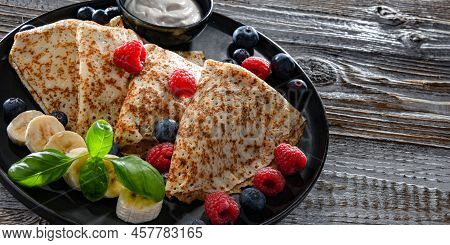 A Plate Of Pancakes With Cheese And Fruits