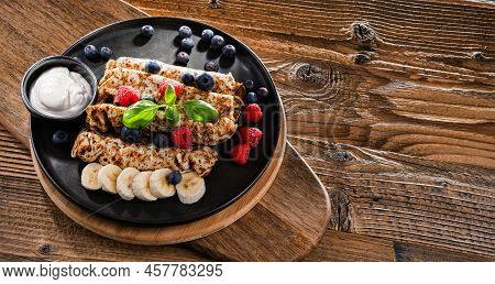 A Plate Of Pancakes With Cheese And Fruits