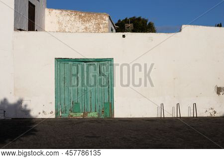Old Traditional Wooden Gte, Always Painted Green At The Island. White Color Of The Facade. Street Of