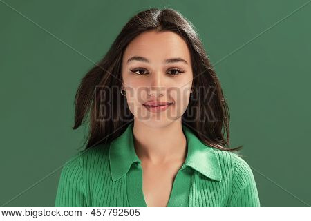 Portrait Of Beautiful Young Girl Attentively Looking At Camera, Posing Isolated Over Green Studio Ba