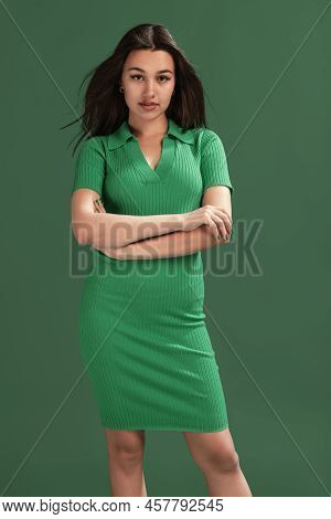 Portrait Of Beautiful Young Girl Posing In Perfect Shape Dress Isolated Over Green Studio Background