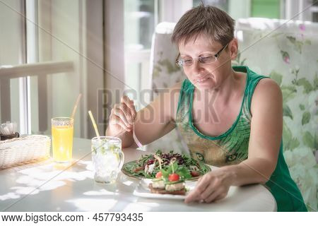 Portrail Of A Woman Eating Salad In A Cafe